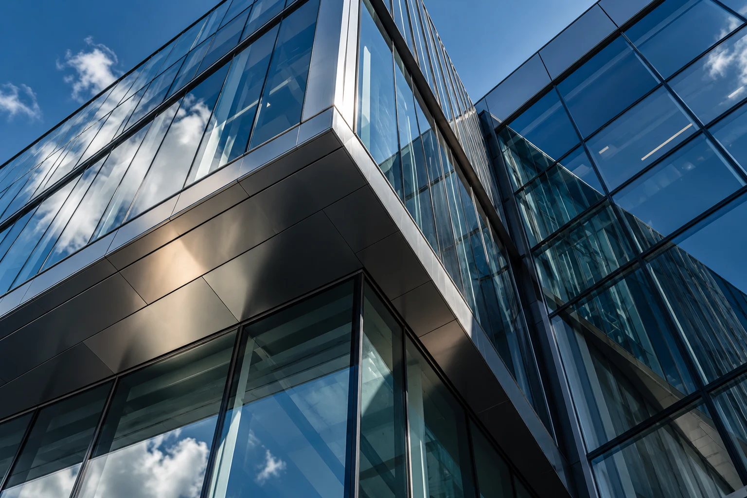 Geometric glass and steel architecture viewed against the sky